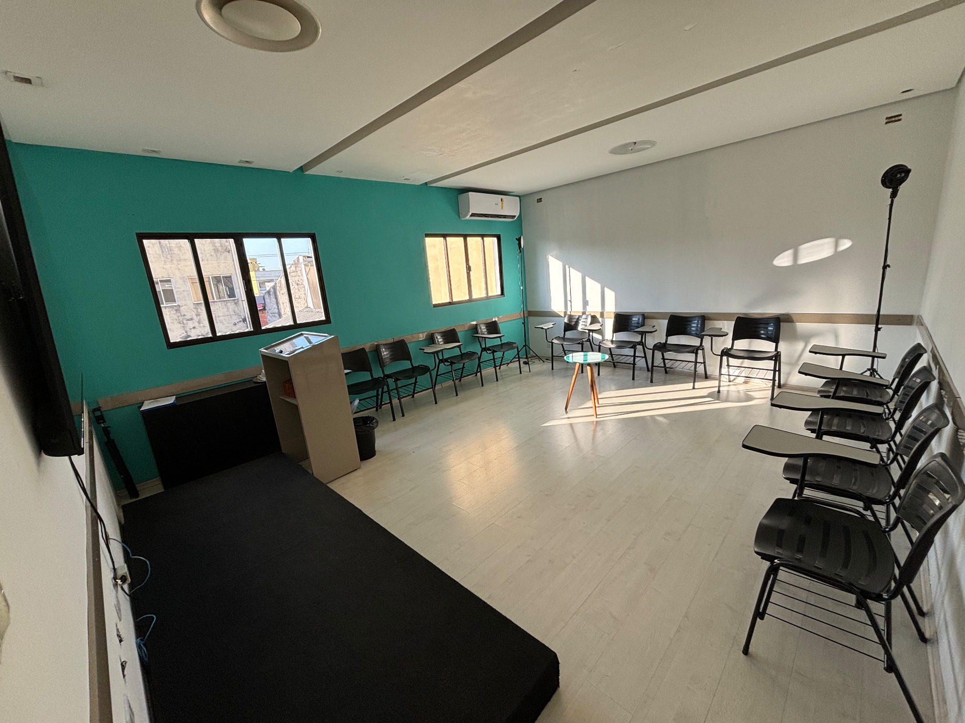 Sala de treinamento montada em U com cadeiras, púlpito e tablado